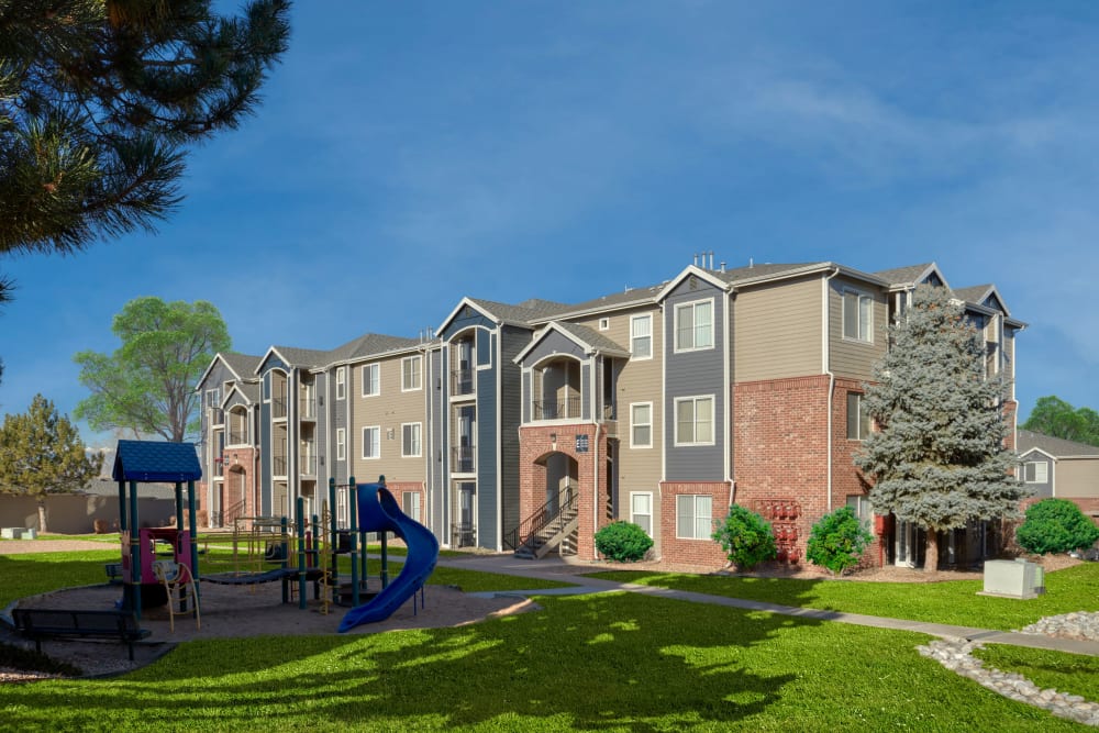 Building exterior with playground at Promenade at Hunter's Glen Apartments in Thornton, Colorado