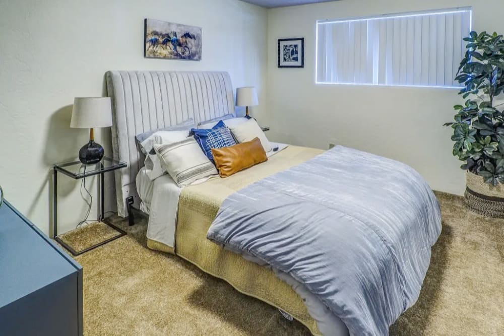 Well lit bedroom with carpeted floors at Gateway Village in Springfield, Oregon