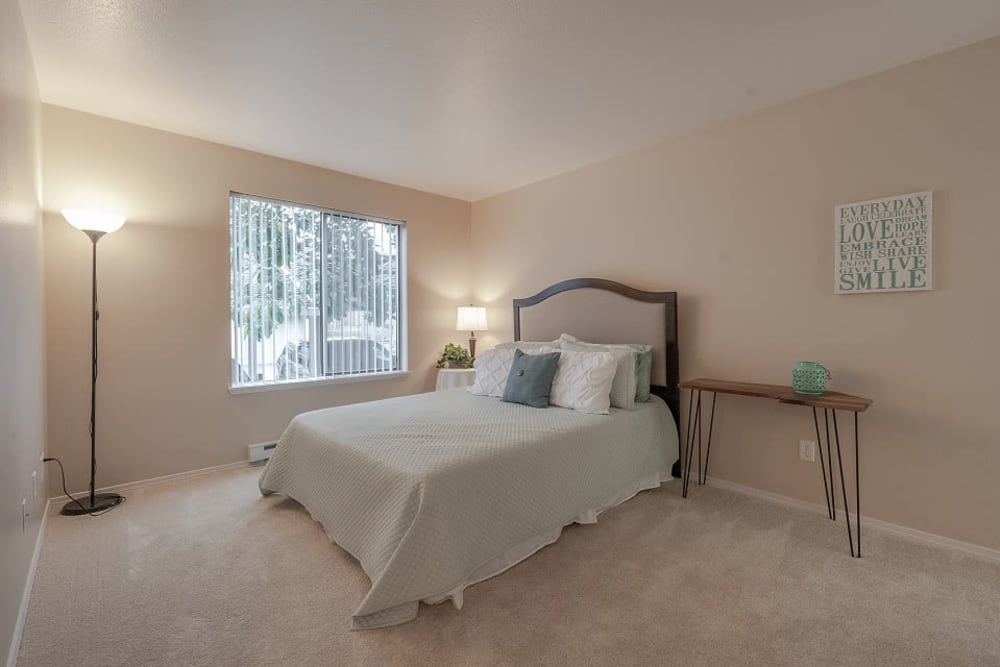 Furnished bedroom with a standing light and carpeted floors at Oswego Cove in Lake Oswego, Oregon