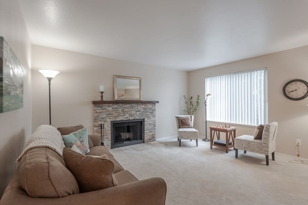 Furnished living room area with a fireplace and carpeted floors at Oswego Cove in Lake Oswego, Oregon