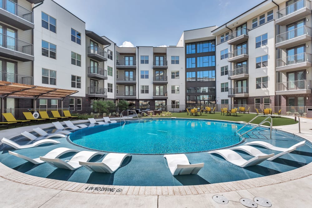 Built-in lounge chairs on the sun deck in the luxurious swimming pool at The Nash in Dallas, Texas