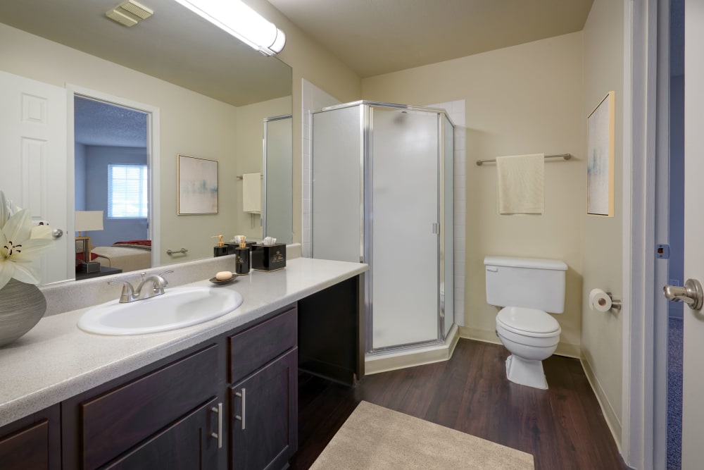 Recently renovated bathroom with brown cabinets and a large tub at Bluesky Landing Apartments in Lakewood, Colorado
