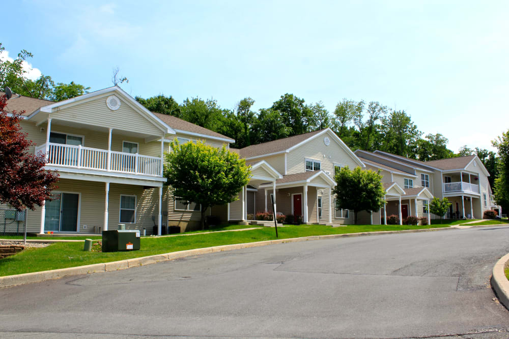 Mature trees and green grass outside resident buildings at Eagle Rock Apartments & Townhomes at Rensselaer in Rensselaer, New York