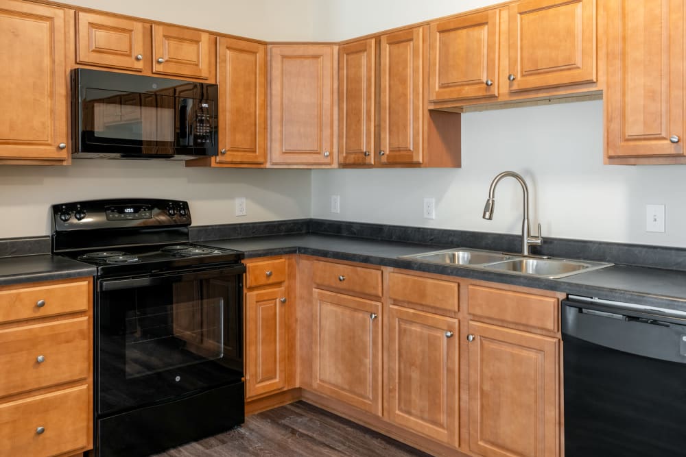 Kitchen with oak cabinetry at Cane Run Station Apartments in Louisville, Kentucky
