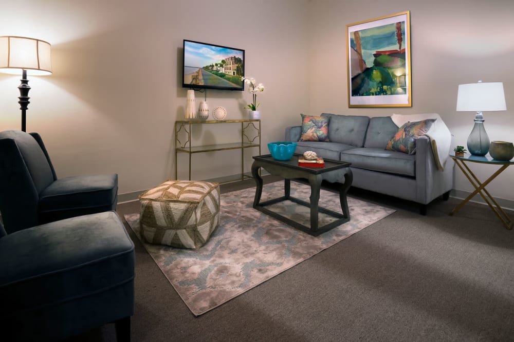 Living room with a couch, 2 chairs, and a wall mounted tv at The Blake at Charlottesville in Charlottesville, Virginia
