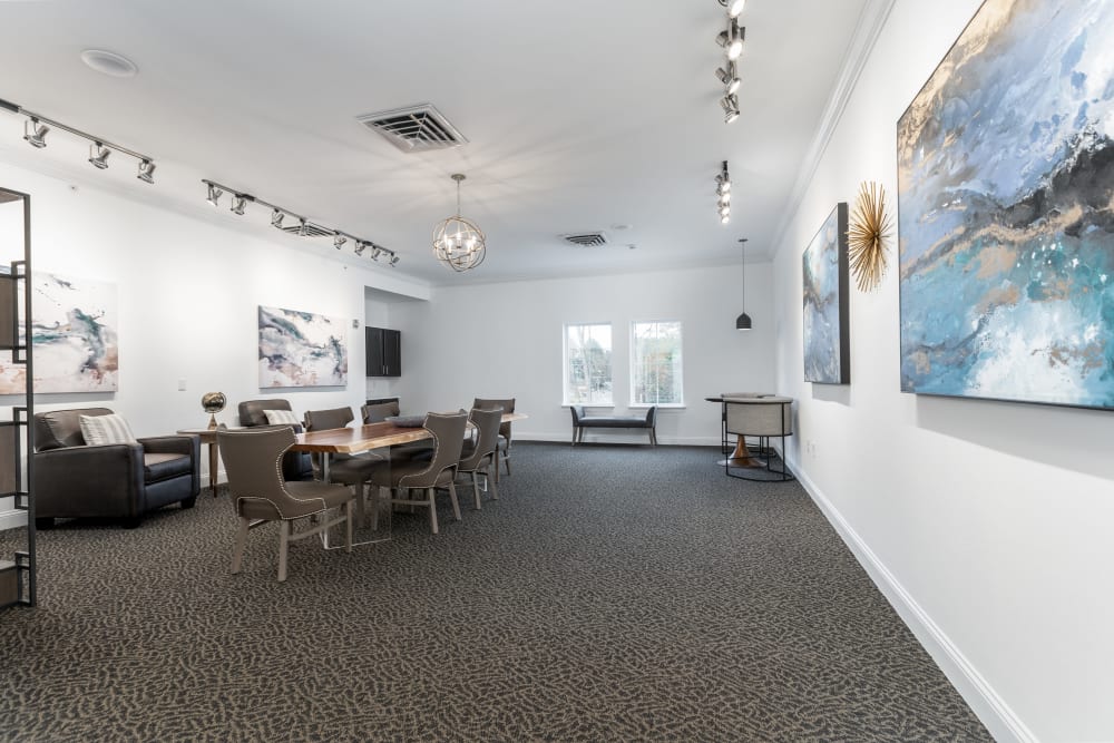 Lounge room with wall art, a large meeting table, and plush chairs at The Blake at Charlottesville in Charlottesville, Virginia