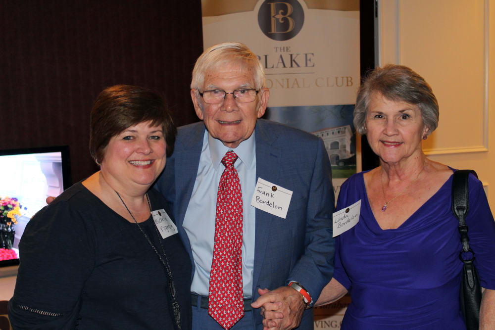 Resident couple with a caretaker at the opening event for The Blake at Colonial Club in Harahan, Louisiana