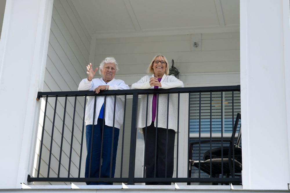 Resident and caretaker waving from a balcony at The Blake at Kingsport in Kingsport, Tennessee