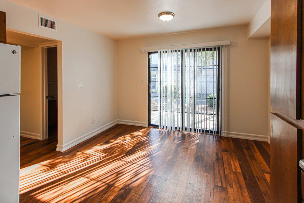 A sunny room with wood flooring and a sliding glass door in a home at Howard Gilmore Terrace in La Mesa, California