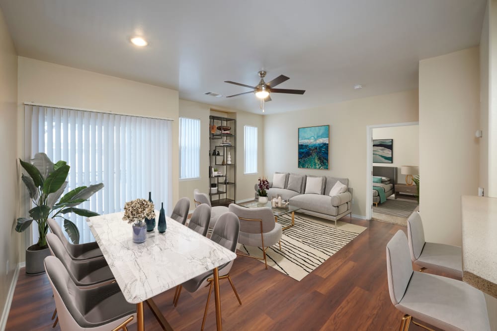 Dining room and living room with wood-style flooring at Promenade at Hunter's Glen Apartments in Thornton, Colorado