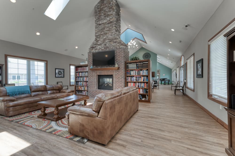 Lounge area with a tv, books and a fireplace at Addington Place of Sparta in Sparta, Illinois
