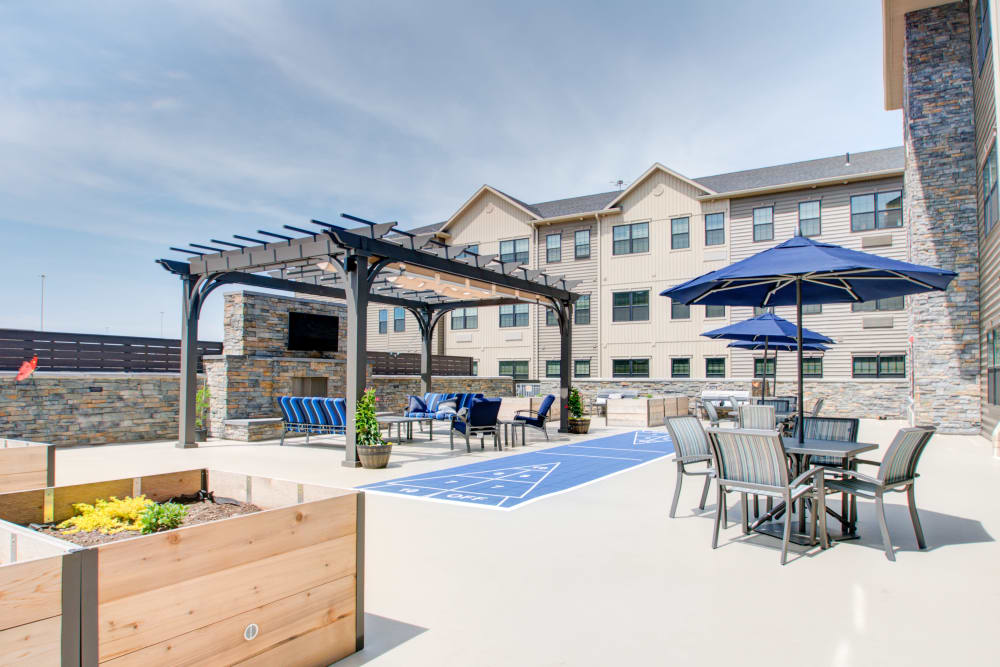 Large patio with outdoor furniture, shade awning and games at The Pinnacle in Plymouth Meeting, Pennsylvania
