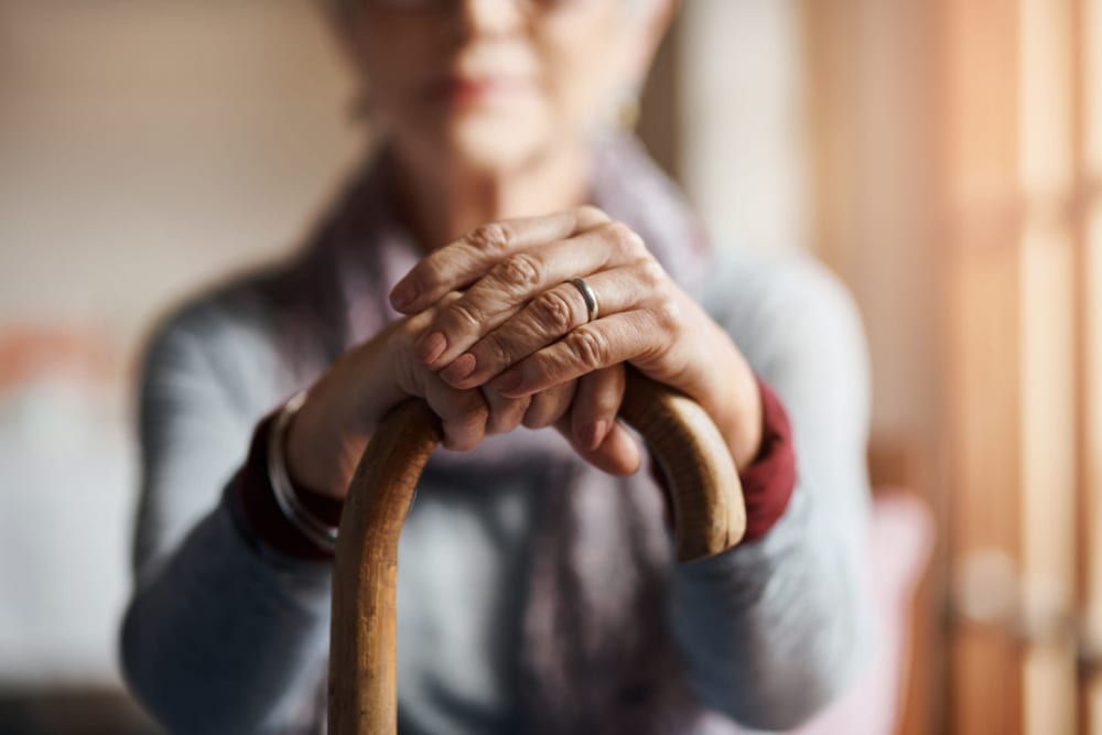 Resident with hands resting on her cane at Belmare Senior Living in Oakdale, California