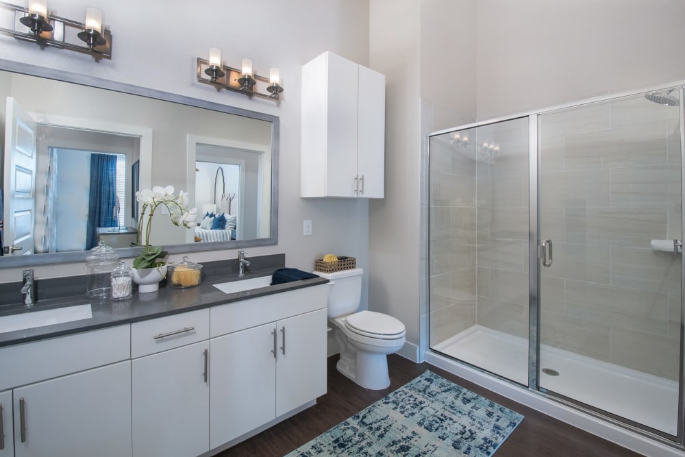 Bathroom with granite countertops and a modern shower at Marquis Dominion in San Antonio, Texas