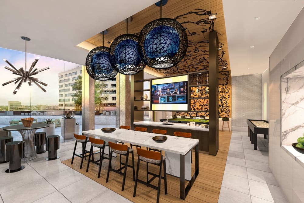 Modern resident lounge with an exhibition kitchen, shuffleboard table, and billiards at Solaire 8200 Dixon in Silver Spring, Maryland