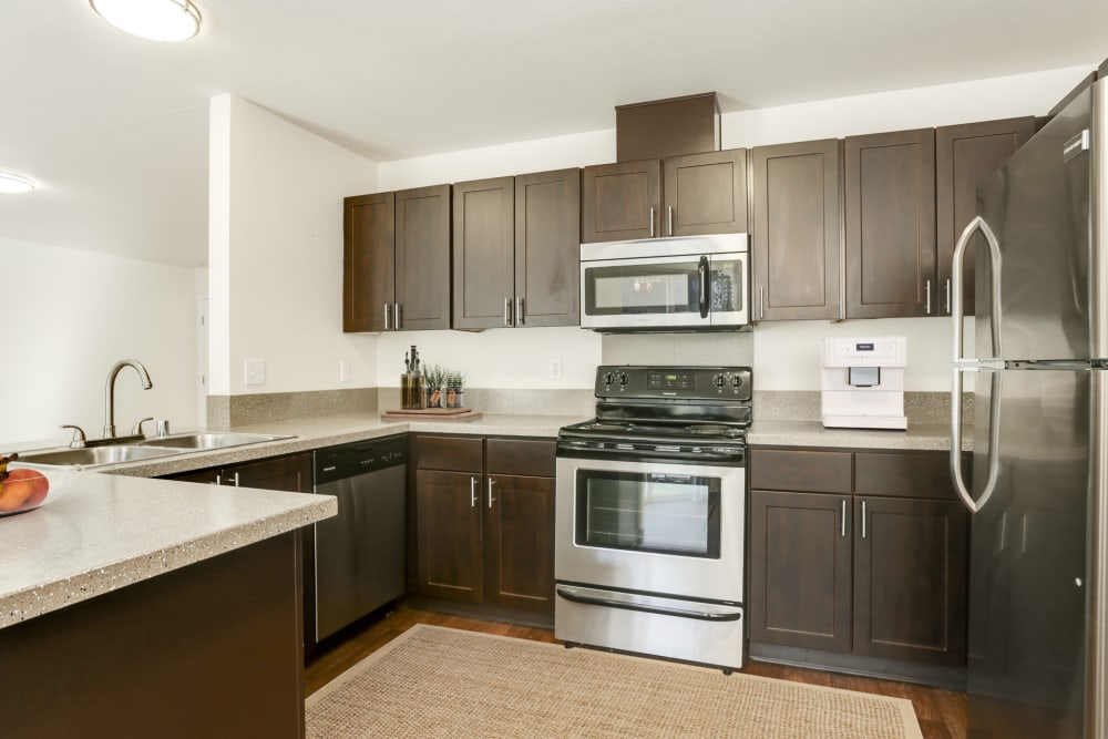 Kitchen with wood-style flooring at The Addison Apartments in Vancouver, Washington