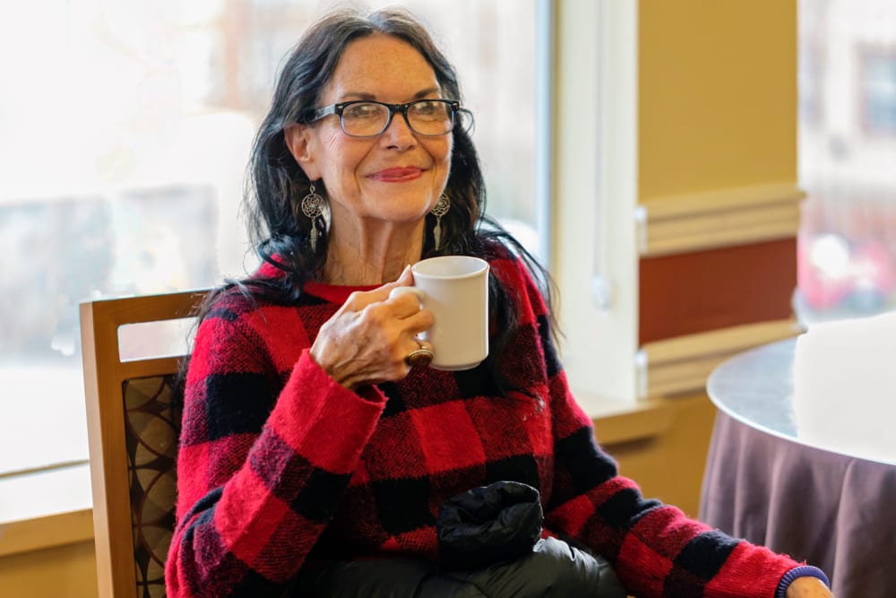 Happy resident enjoying some afternoon tea at Cascade Park Vista Assisted Living in Tacoma, Washington