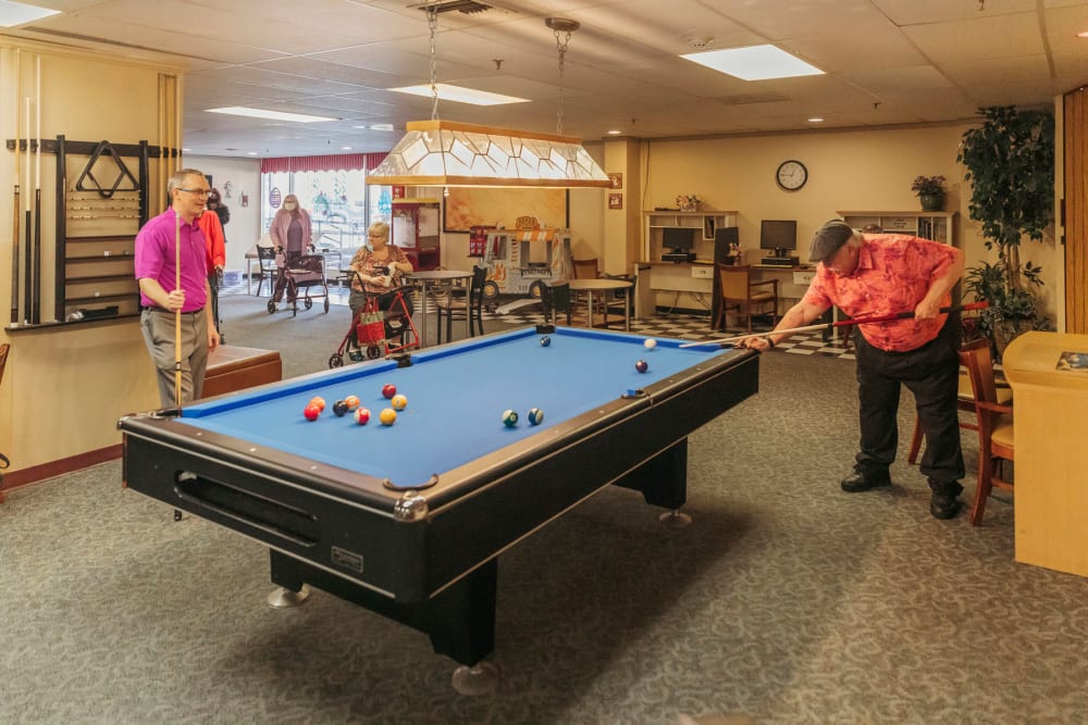Resident clubhouse with a billiards table and more at Cascade Park Vista Assisted Living in Tacoma, Washington