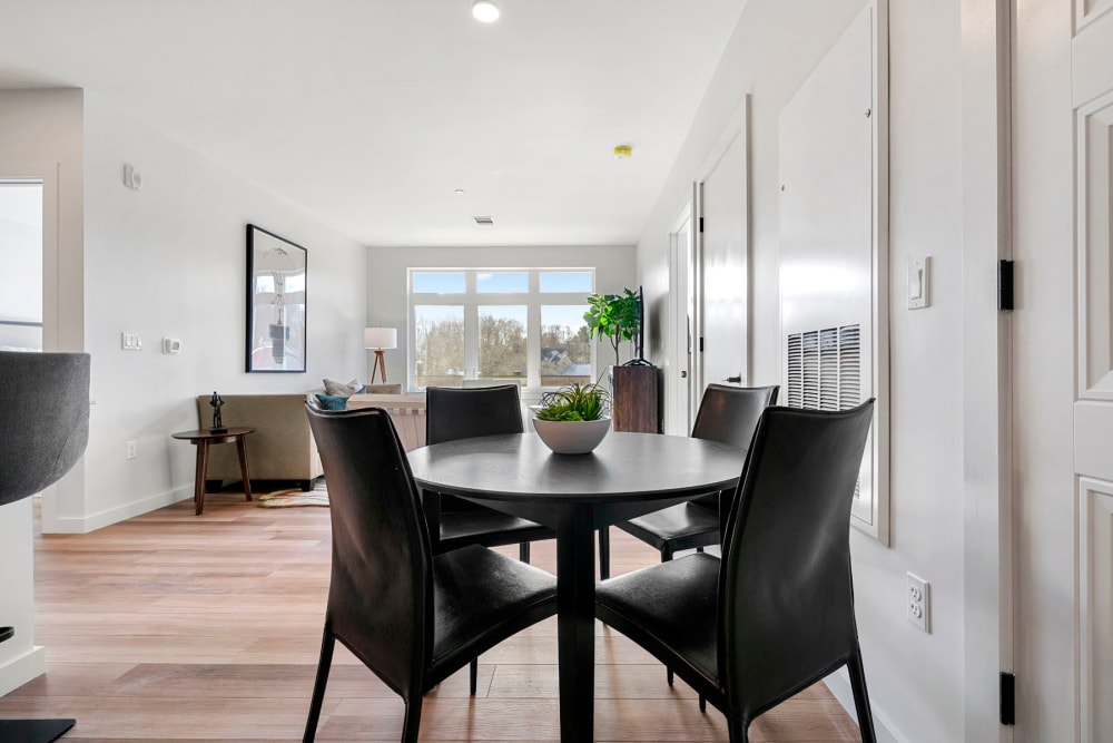 Dining area with a view of the living space in a model home at Anden in Weymouth, Massachusetts