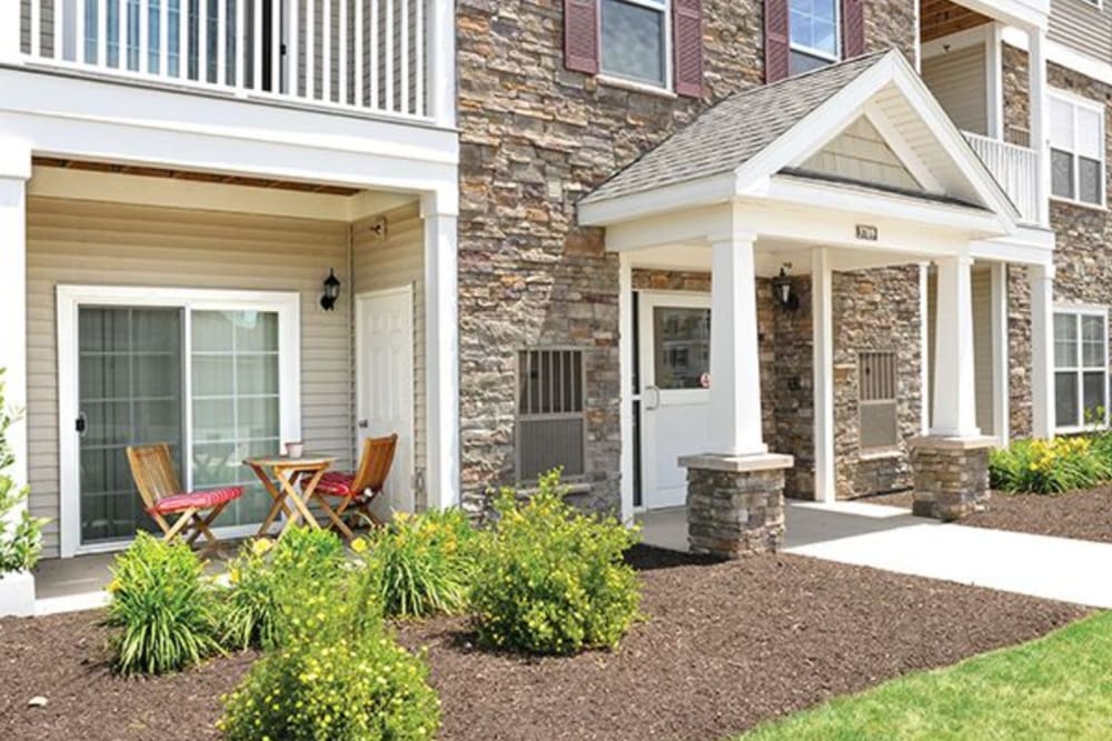 Exterior view of resident building entrance and well-manicured landscaping at Rivers Pointe Apartments in Liverpool, New York