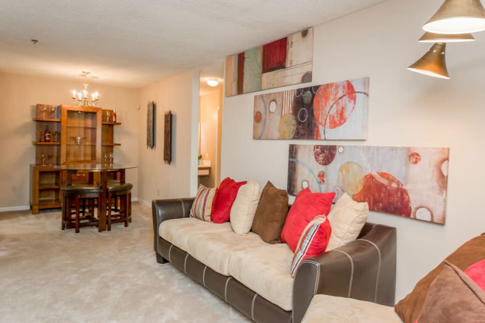 Cozy living room in a model home with carpeted floors at Arbor Crossing Apartments in Lithonia, Georgia