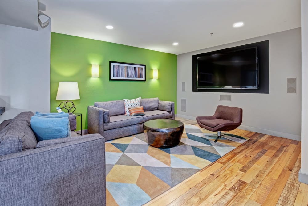 Lounge area in the clubhouse with a big tv on the wall at Alley South Lake Union in Seattle, Washington