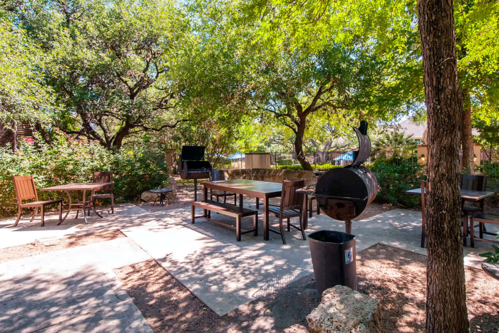 Lushly landscaped barbecue area with charcoal grills at Sonterra Heights in San Antonio, Texas