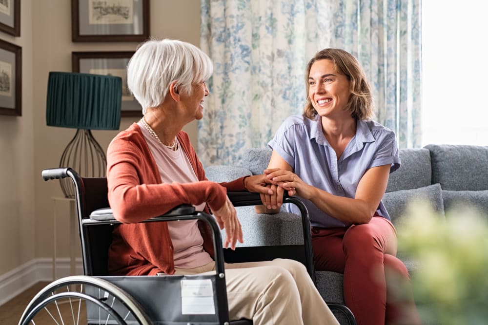 Wheelchair bound resident talking with medical staff at an English Meadows community