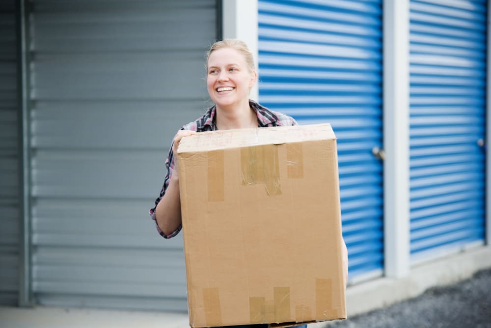 a customer walking with a box at American Self Storage – East Pittsboro in Pittsboro, North Carolina