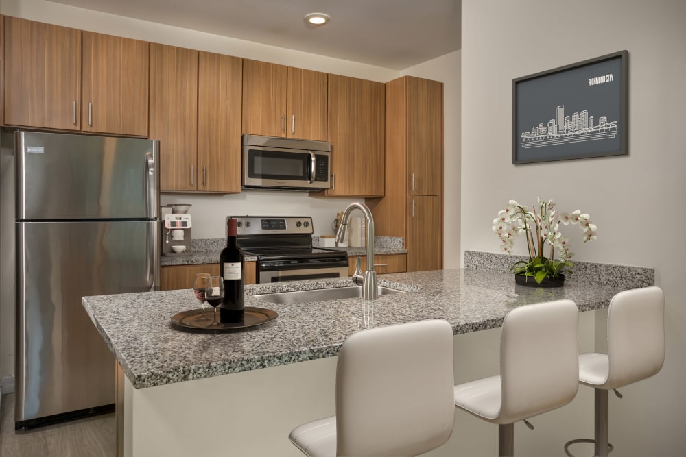 Kitchen with granite countertops and bar stools at The Preserve Scott's Addition in Richmond, Virginia