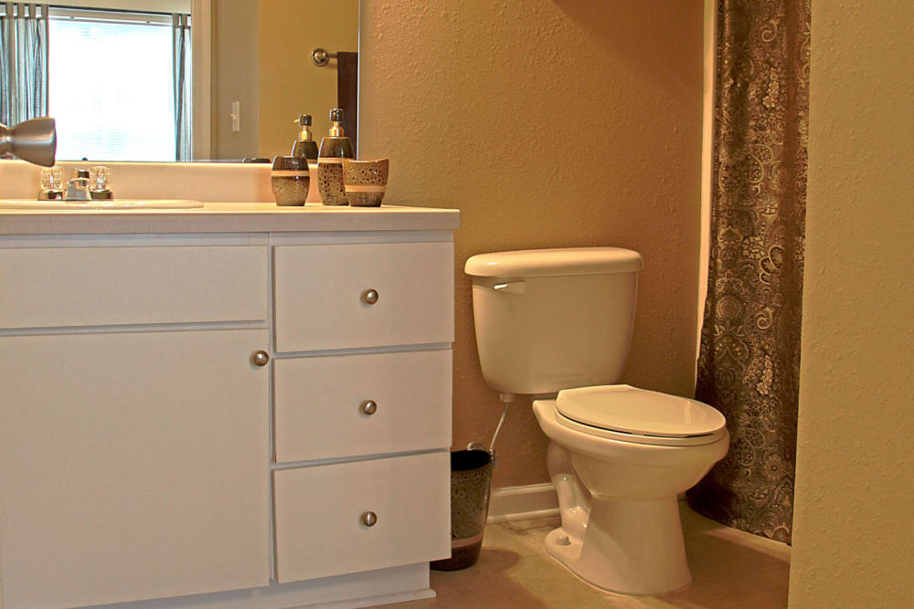 Bathroom with white cabinetry at The Gardens on Stadium in Phenix City, Alabama