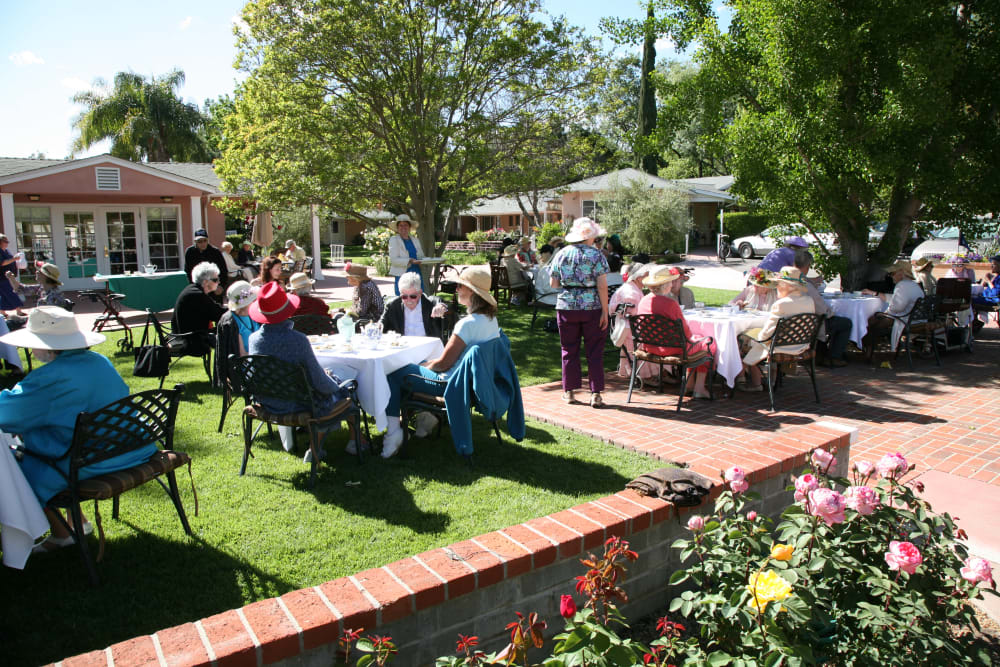 Residents seated at tables in the garden at Gables of Ojai in Ojai, California