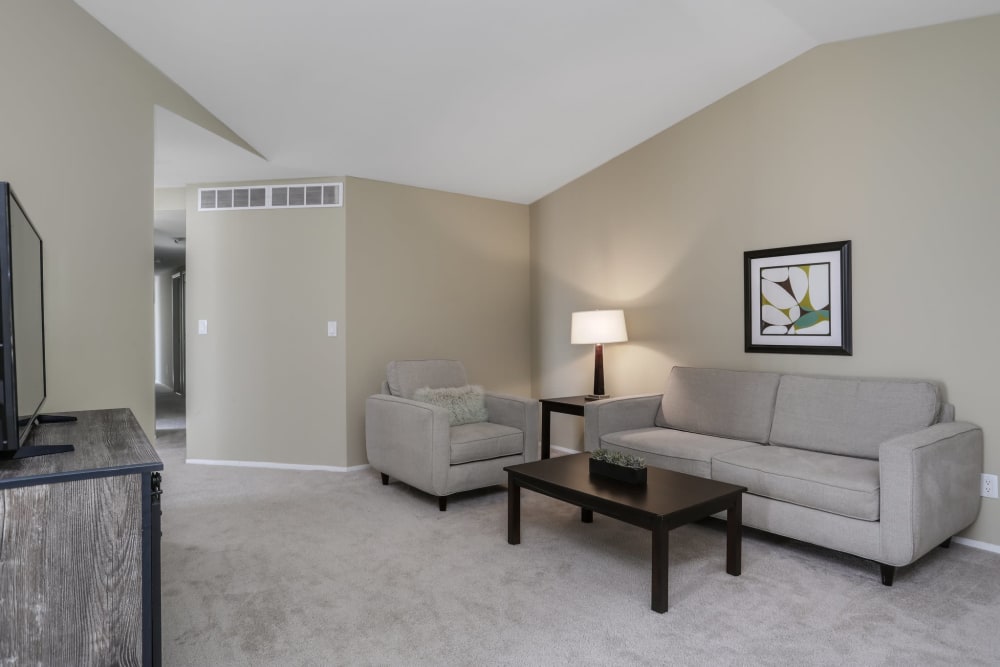 Living room with a flat screen TV in a furnished suite at Farmington Oaks Apartments in Farmington, Michigan
