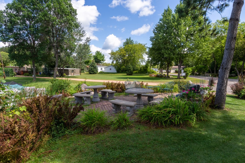 Lush and verdant landscape surrounding a picnic area at Edgewater Homes in Rhinelander, Wisconsin