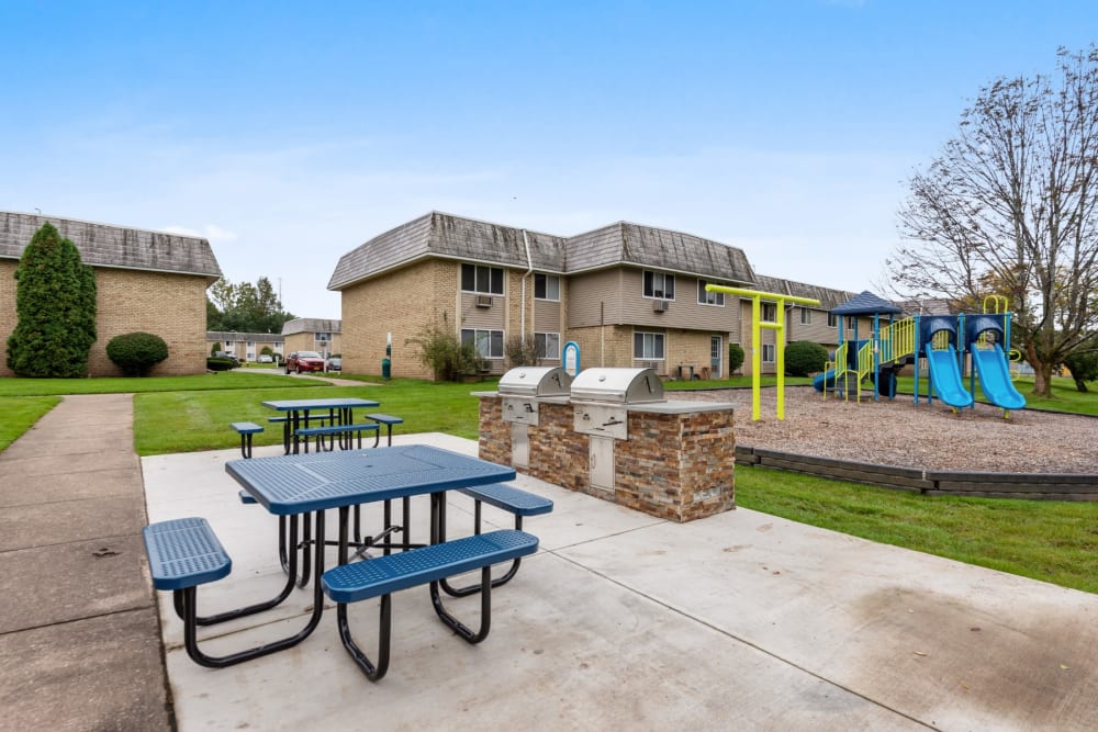 Grilling station and picnic benches at Hilton Village II Apartments in Hilton, New York