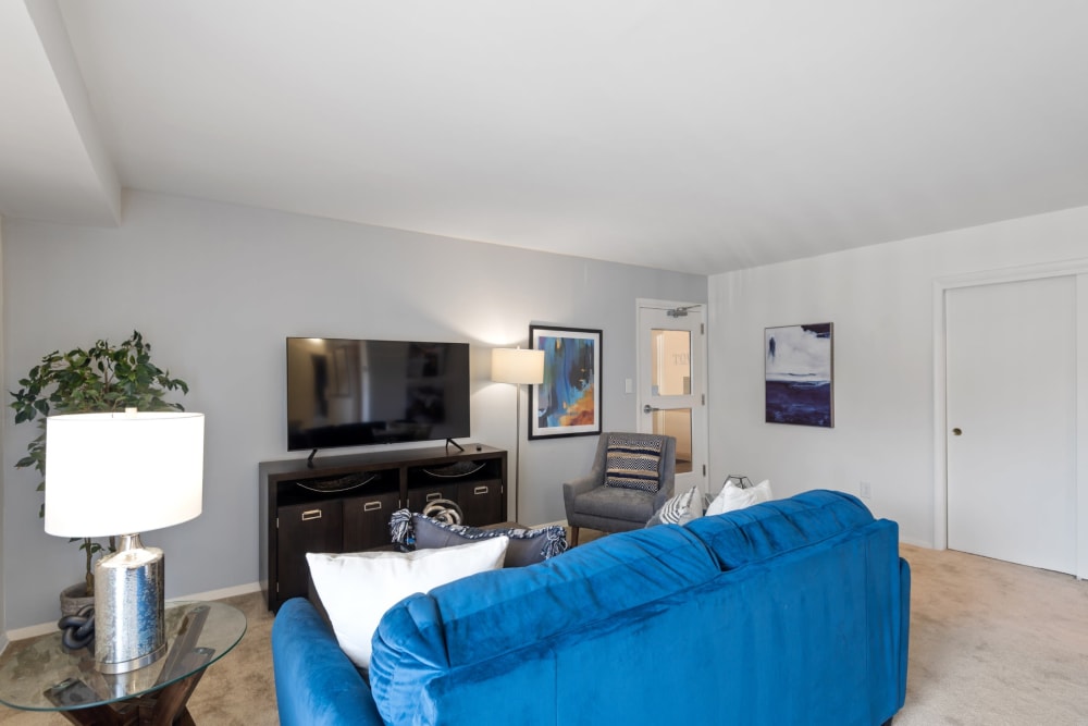 A living room with wall to wall carpeting in a home at Towson Crossing Apartment Homes in Baltimore, Maryland