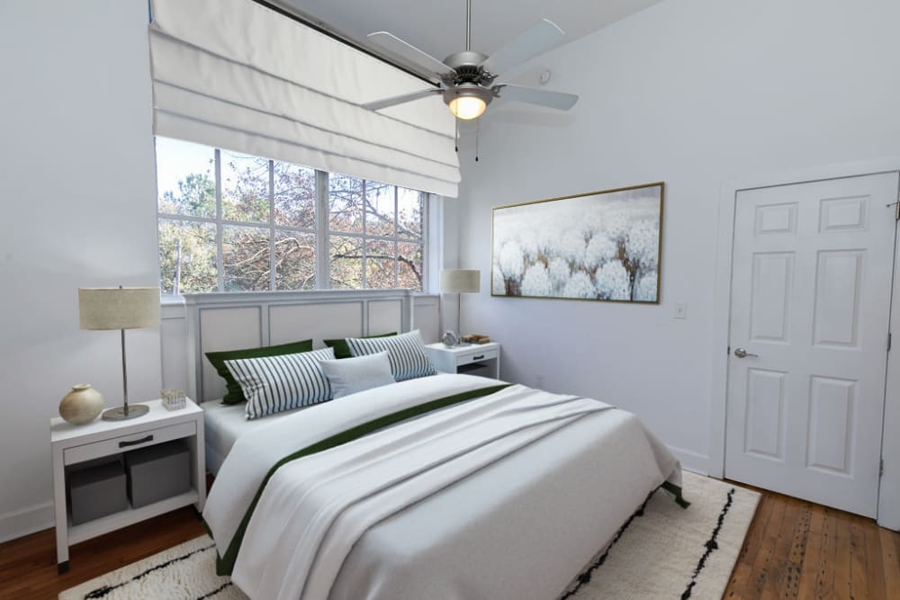 Modern bedroom with large windows and white walls at Roosevelt Historic Lofts in Atlanta, Georgia