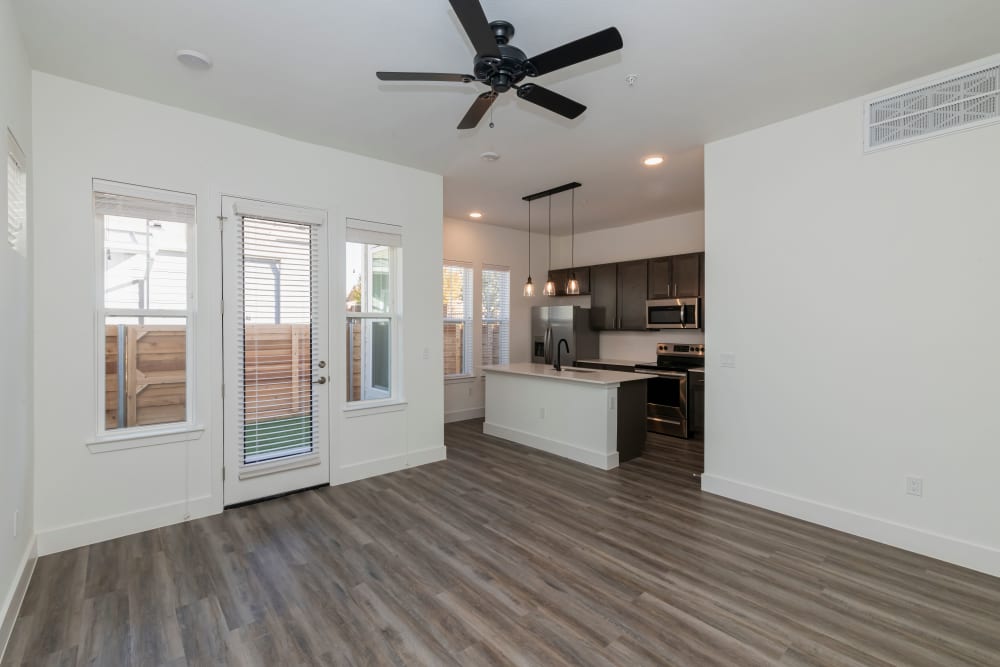 Open living room and kitchen with plank flooring at Elevate at Skyline in McKinney, Texas
