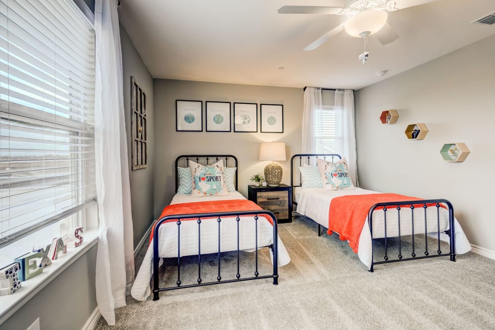 Two twin beds in the kids room of a model home at BB Living Harvest in Argyle, Texas