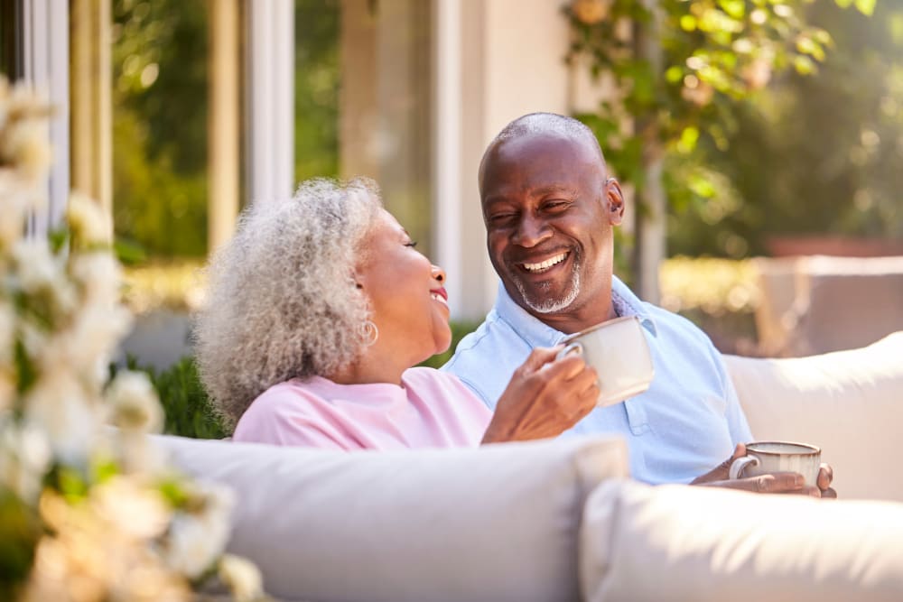 Resident couple smiling and laughing outside at Lake Park Senior Living in Oakland, California