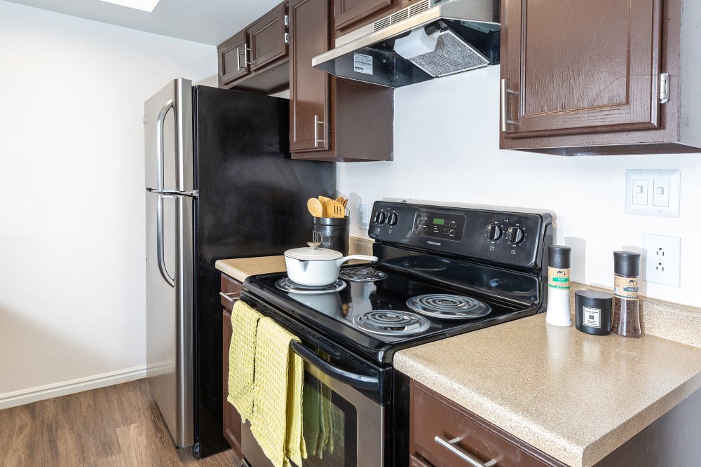 Kitchen with espresso cabinets and bar seating at Shadowbrook Apartments in West Valley City, Utah