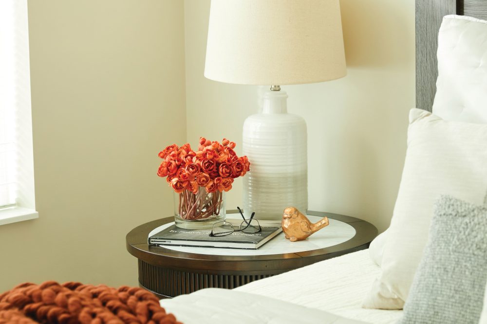 Flowers on a nightstand next to the bed in a model apartment at SL location 1 in Bend, Oregon