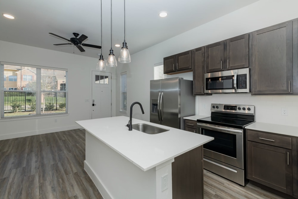 Dark wood cabinets and stainless steel appliances in the kitchen at parcHAUS AT CELINA PARKWAY in Celina, Texas