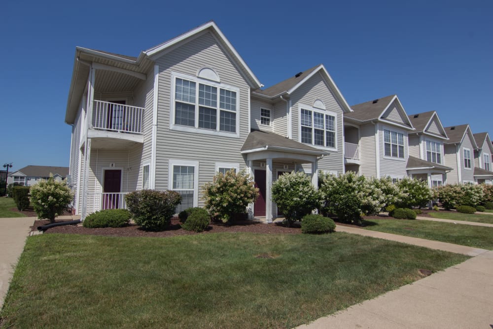 Exterior with professionally landscaped lawns and a wide sidewalk at Lake Pointe Apartment Homes in Portage, Indiana