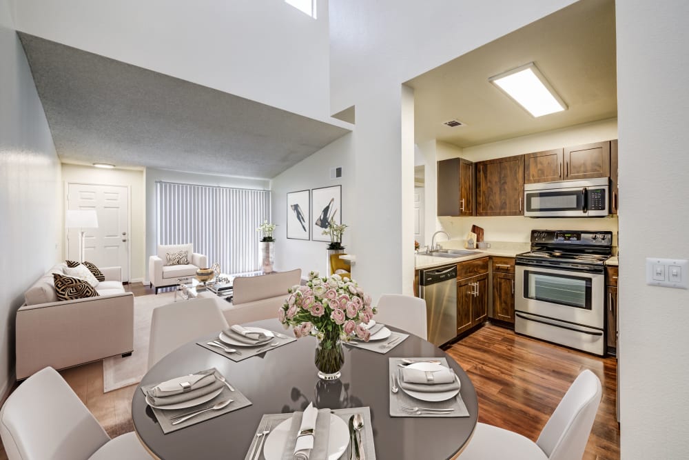 A dining room, kitchen and living room view of spacious home at Tuscany Village Apartments in Ontario, California