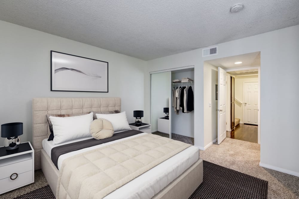 Decorated master bedroom with large windows at Tuscany Village Apartments in Ontario, California