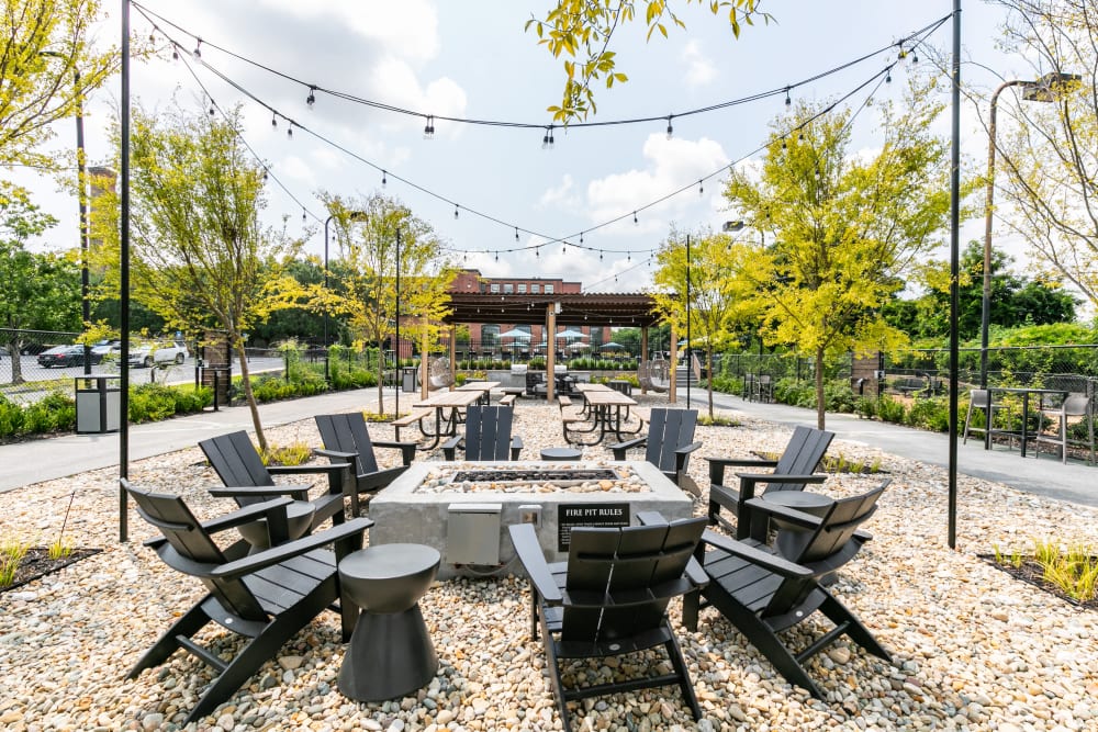  Outdoor community seating and picnic area with fire-pit and Adirondack chairs at Lofts at Riverwalk in Columbus, Georgia