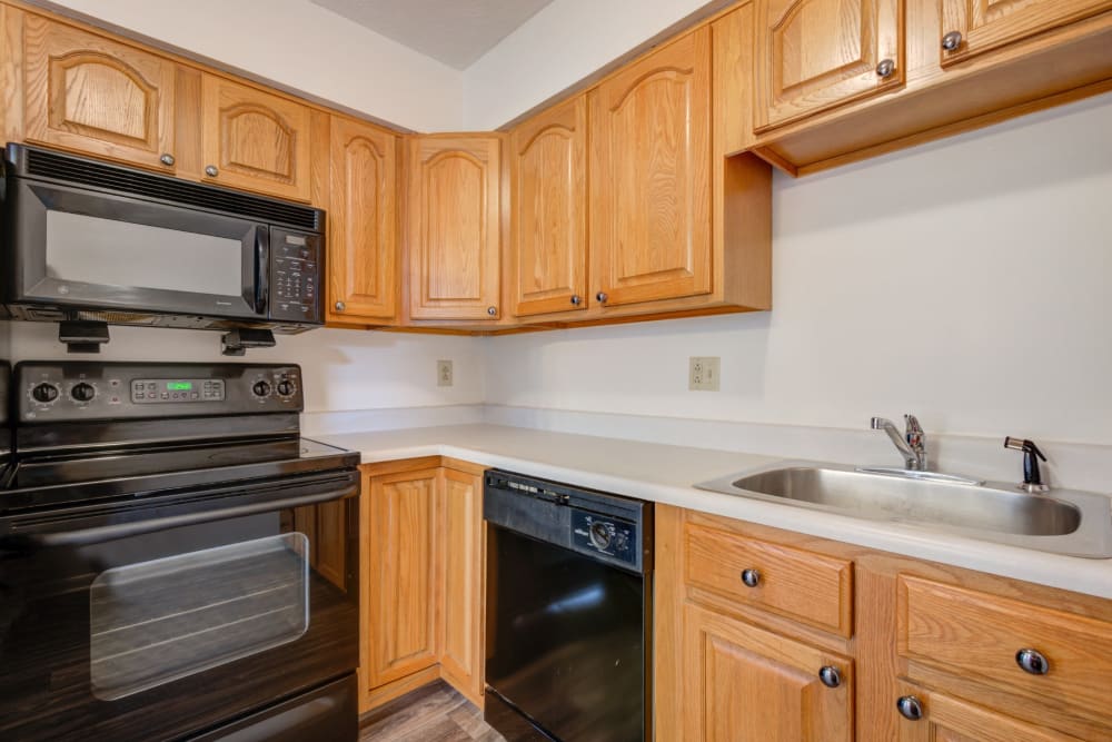 Kitchen with black appliances at Brighton Colony Townhomes in Rochester, New York