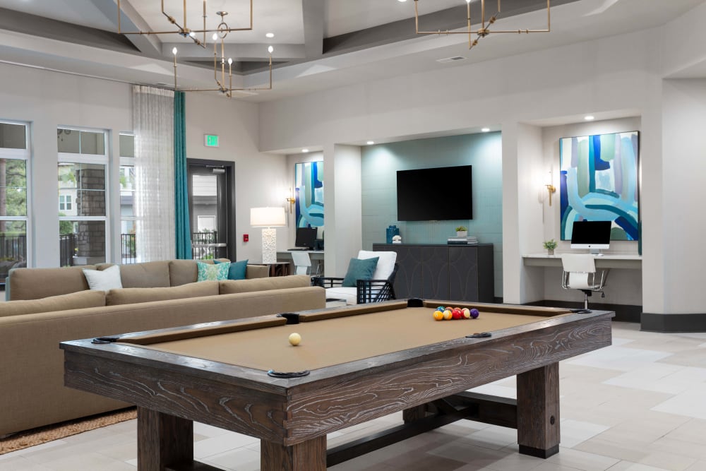 A modern lounge area featuring a billiard table in the cente