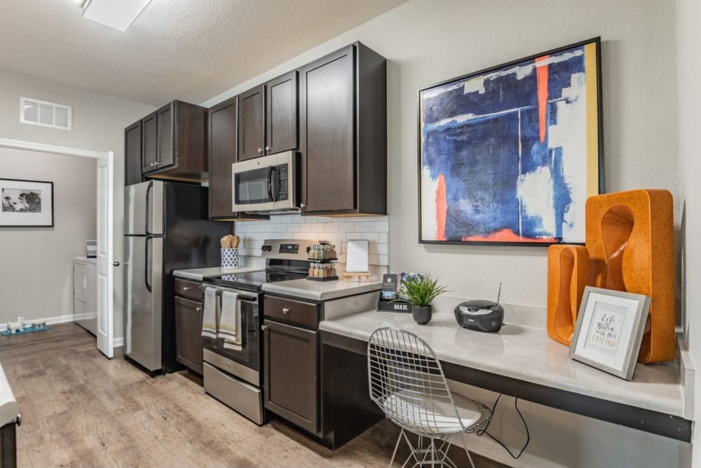 Apartment kitchen with dark cabinets and granite countertops at Art Avenue Apartment Homes in Orlando, Florida